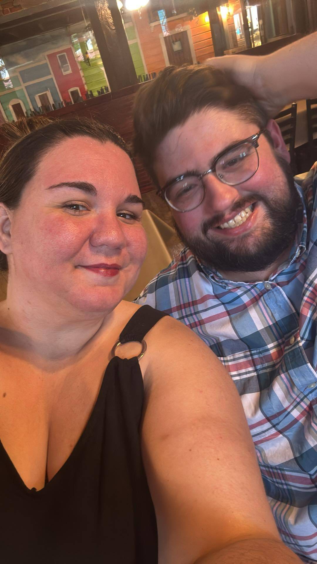 Ashley and Robert smiling indoors.